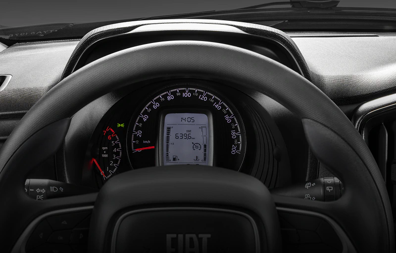 Detalhe do interior de Fiat Mobi com destaque para painel de instrumentos com indicador de troca de marcha, informações sobre consumo e horário.
